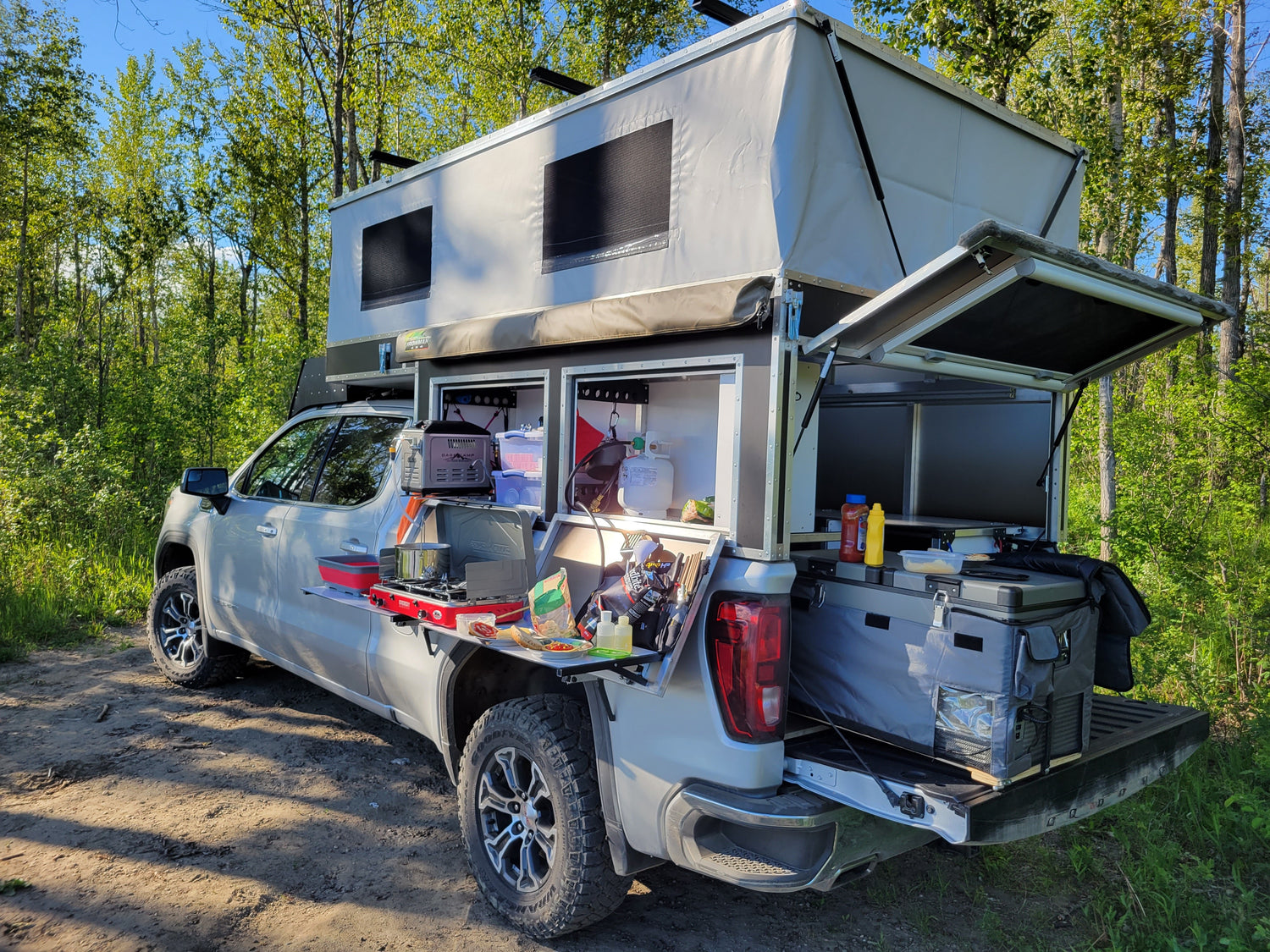 Highly modified OVRLND pop-up camper shell on GMC truck. Customer has done a number of modifications for cooking and camping.