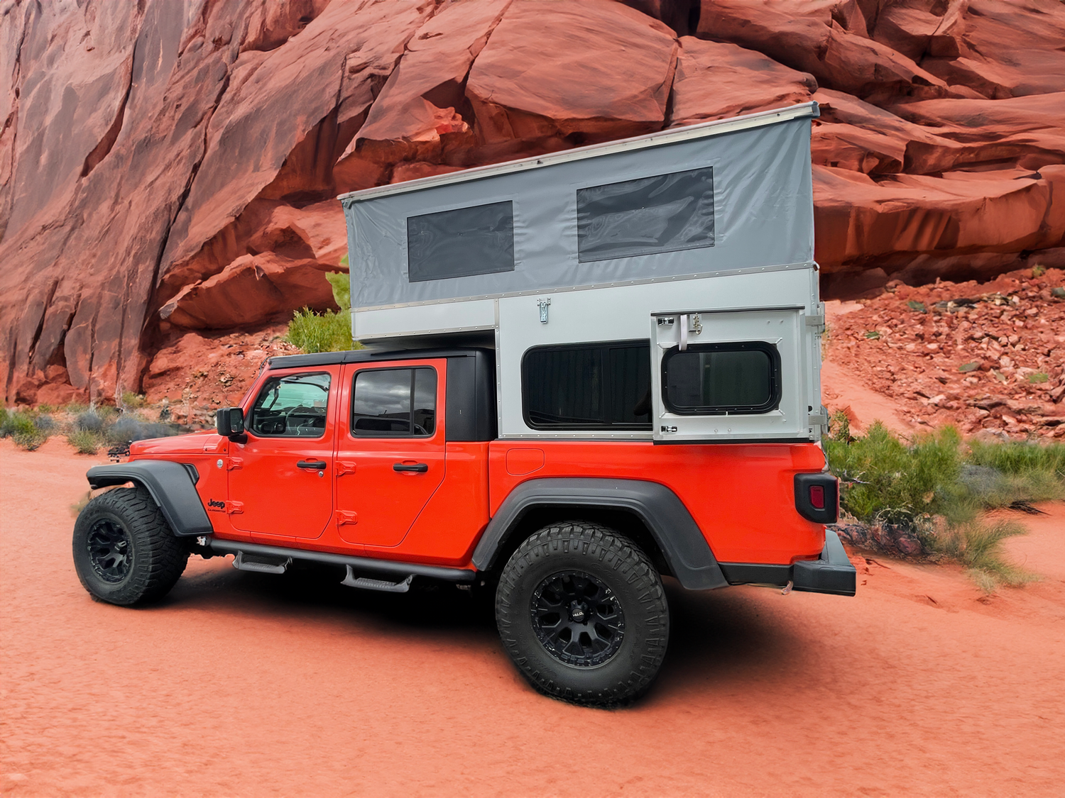 Jeep Gladiator with pop up camper shell in desert landscape. 